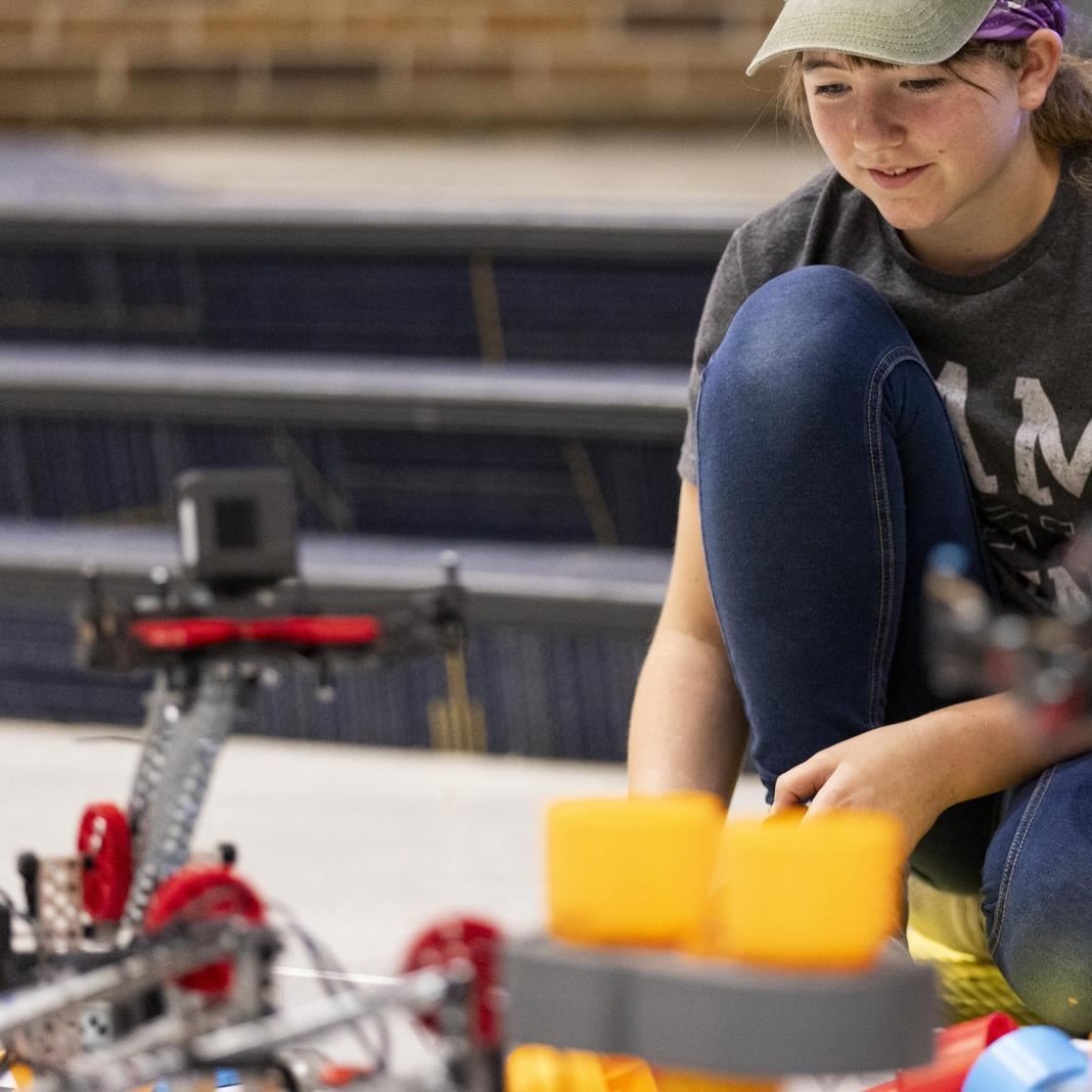 A student works with robots during STEM camp 